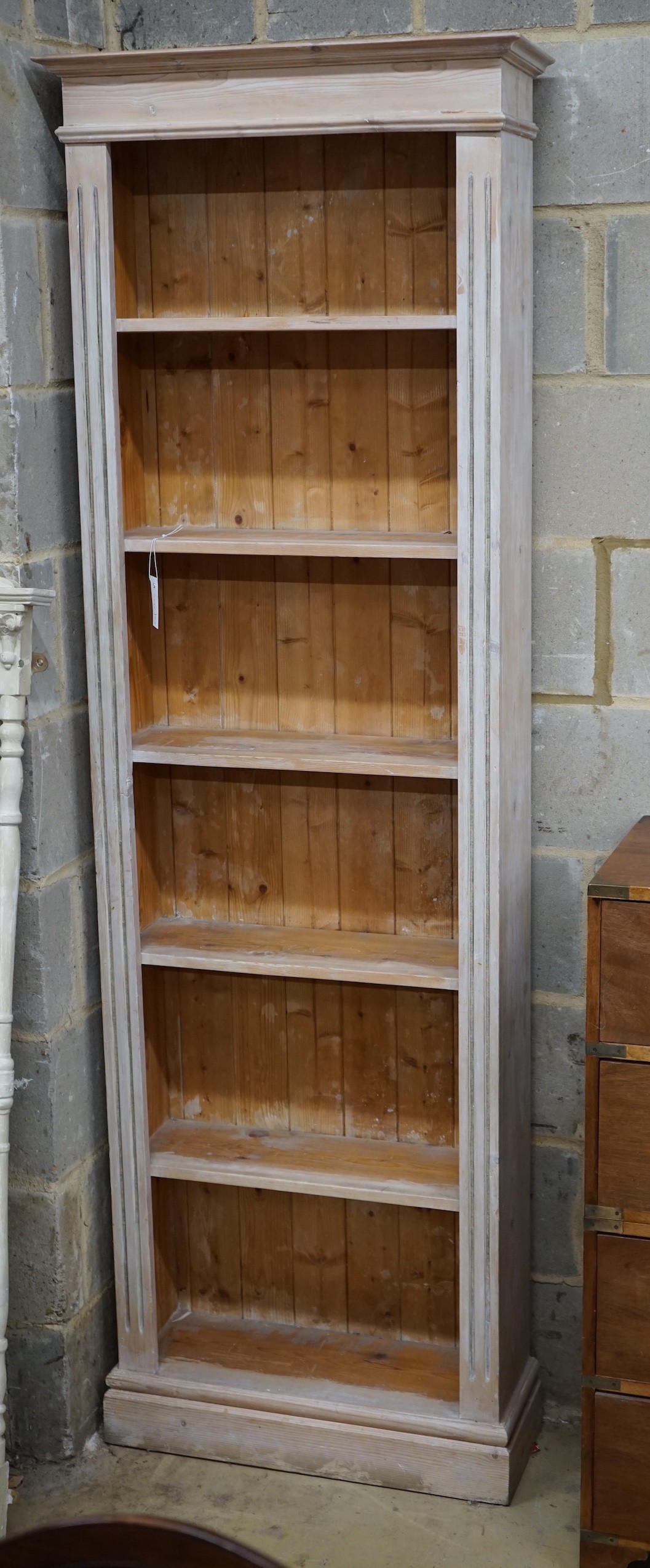 A Victorian style painted pine narrow open bookcase, width 65cm, depth 20cm, height 200cm
